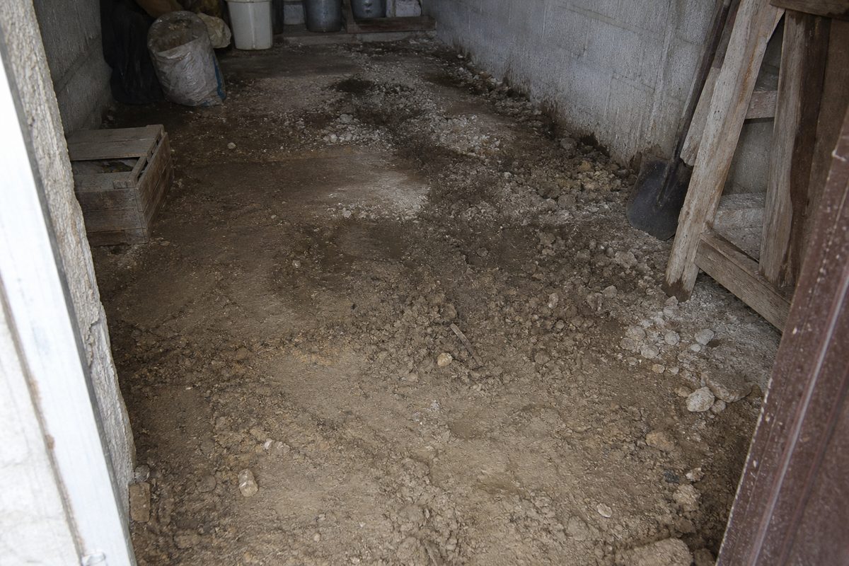 Sample demo before image of a rough earth floor in a storage room